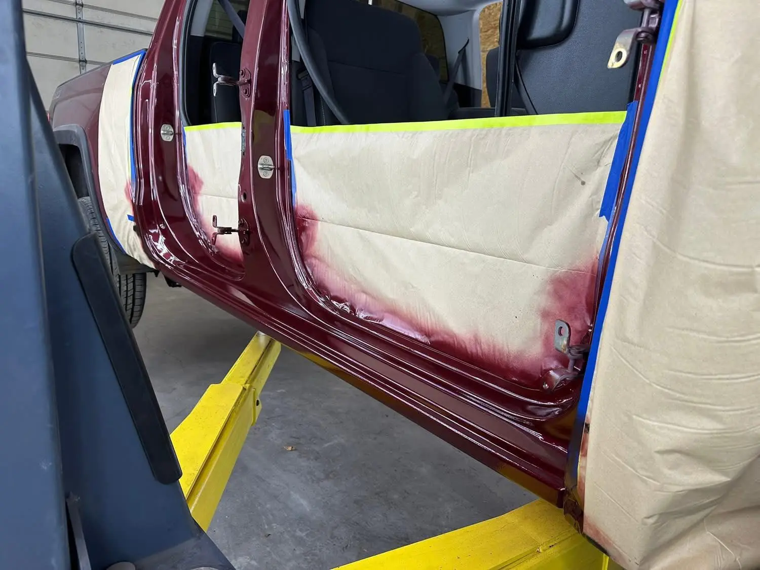 bodywork complete on a red truck up on a lift at Reflections Auto in Auburn Maine