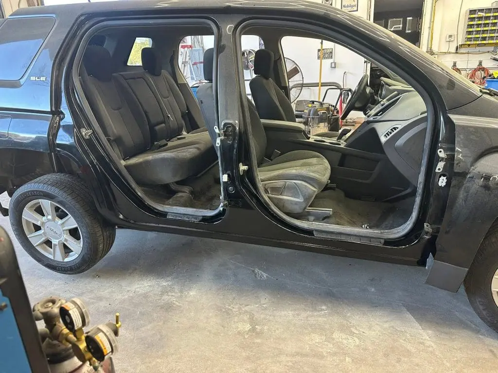bodywork complete on a black car up on a lift at Reflections Auto in Auburn Maine