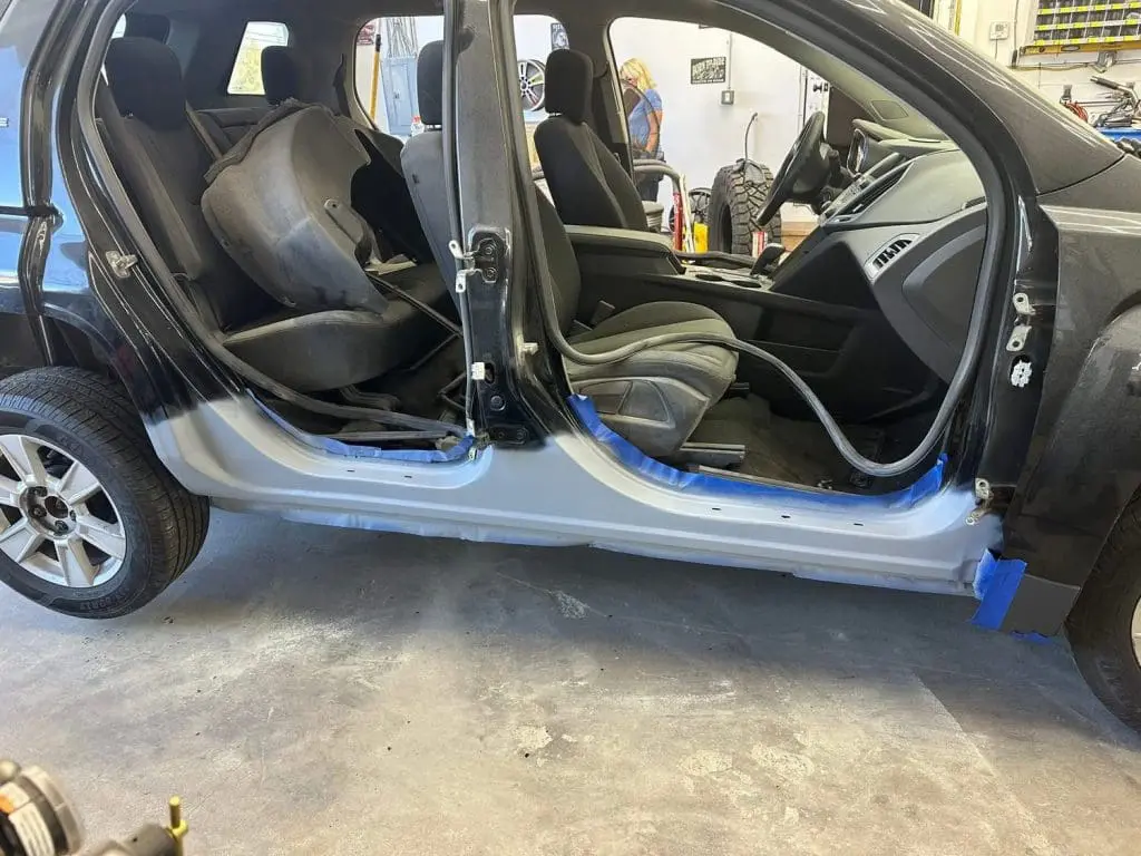 bodywork underway on rocker panels on a black car up on a lift at Reflections Auto in Auburn Maine