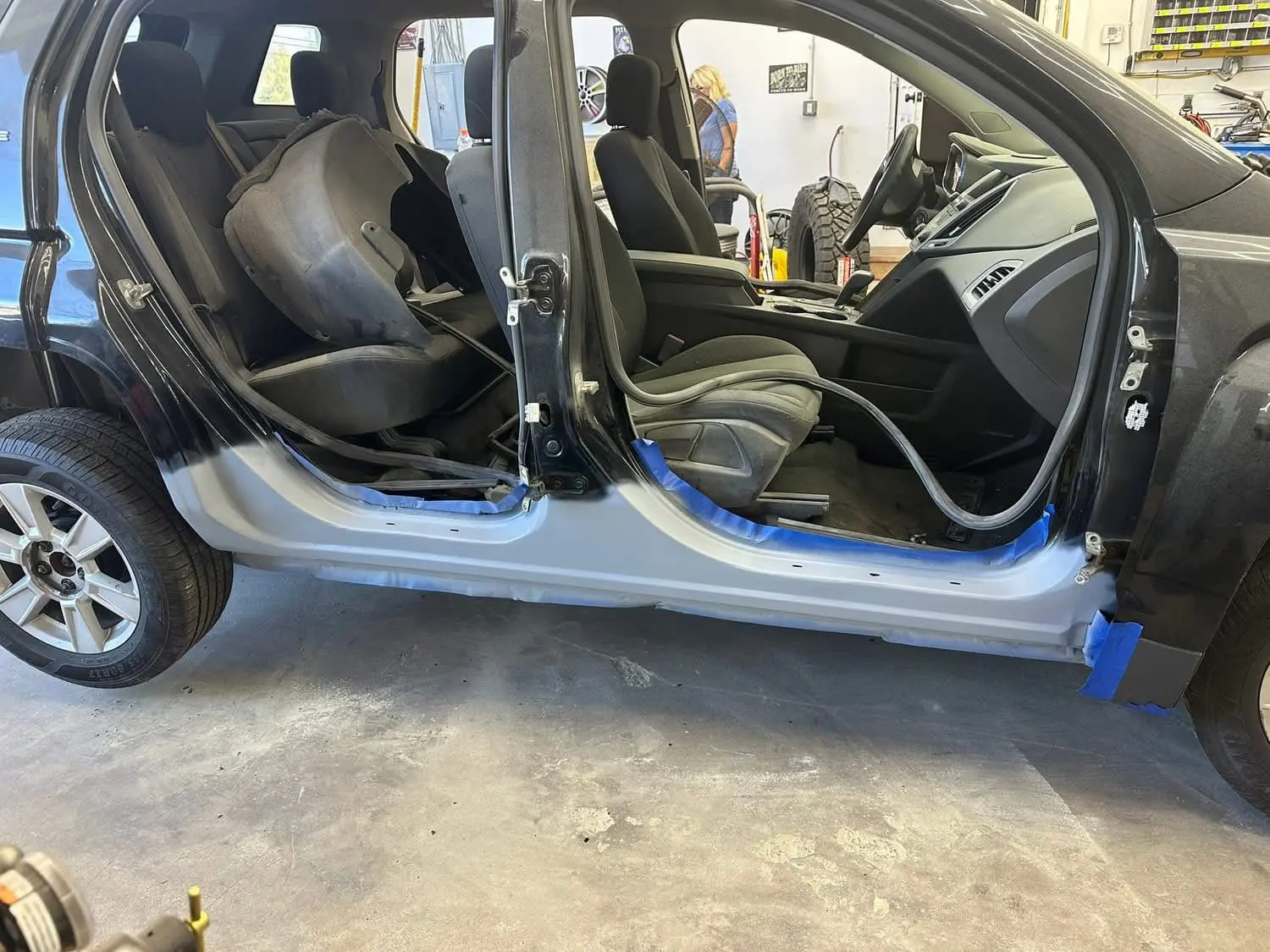 bodywork underway on rocker panels on a black car up on a lift at Reflections Auto in Auburn Maine